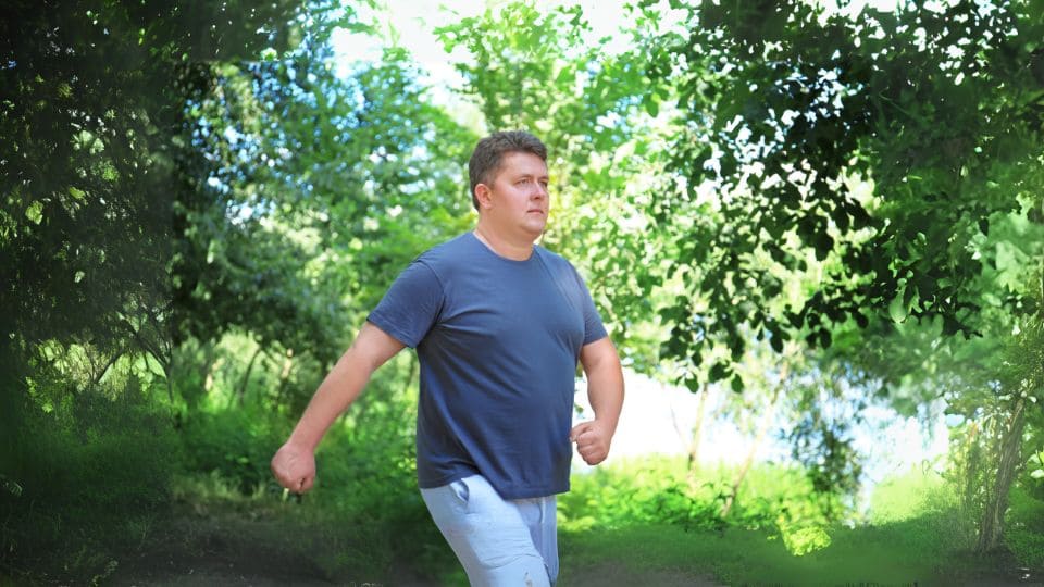 Caminhada para iniciantes, dicas de exercícios para iniciantes, imagem mostra homem com sobrepeso iniciantes sua caminhada ao ar livre.